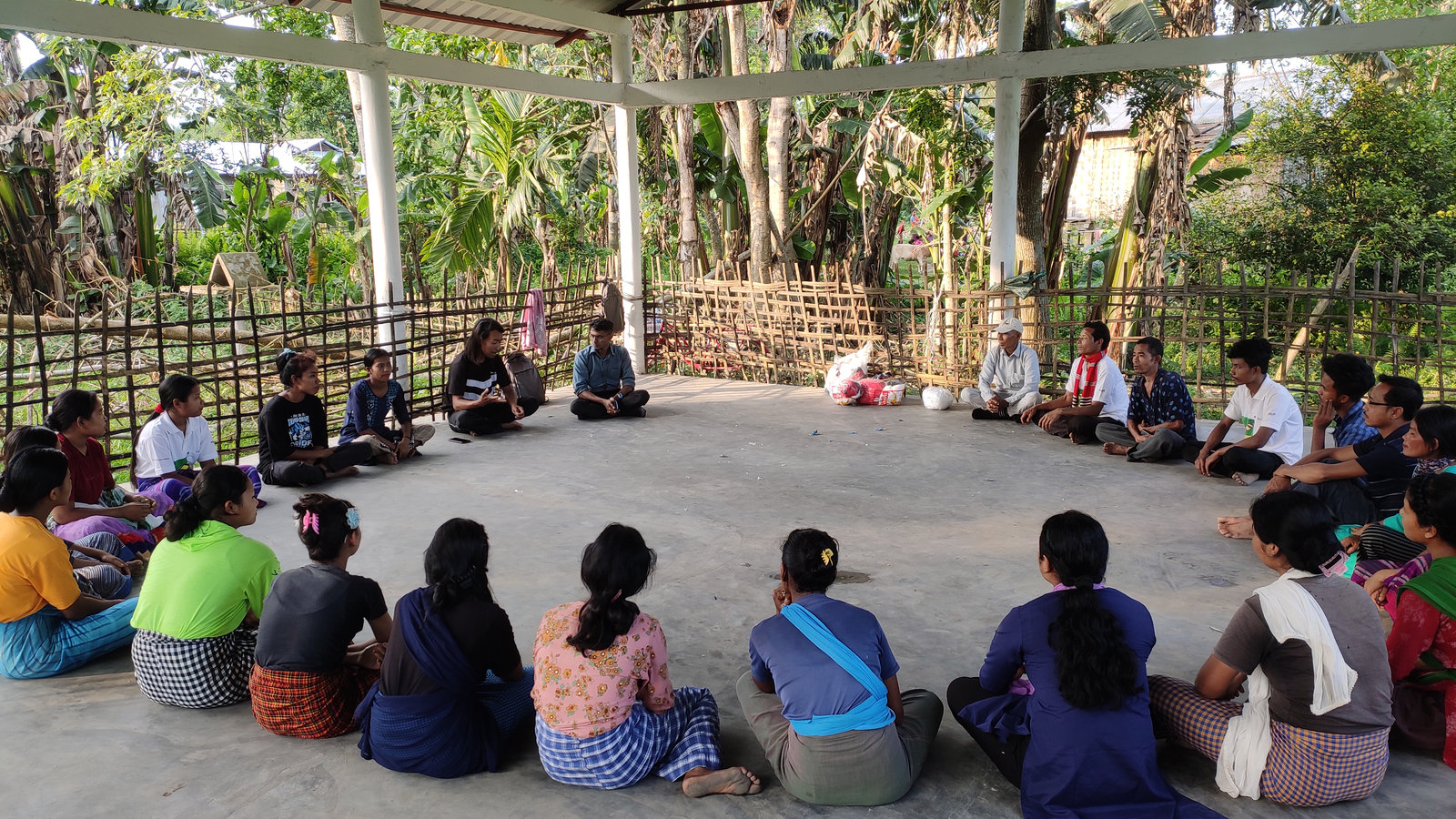 Community members sit in a circle during a group discussion in Majuli
