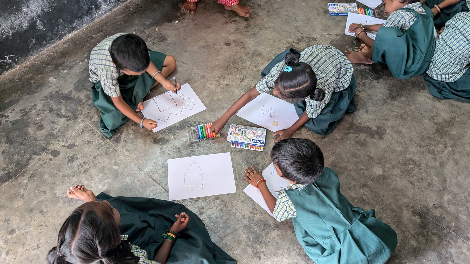 Students sitting on the floor working on an activity sheet