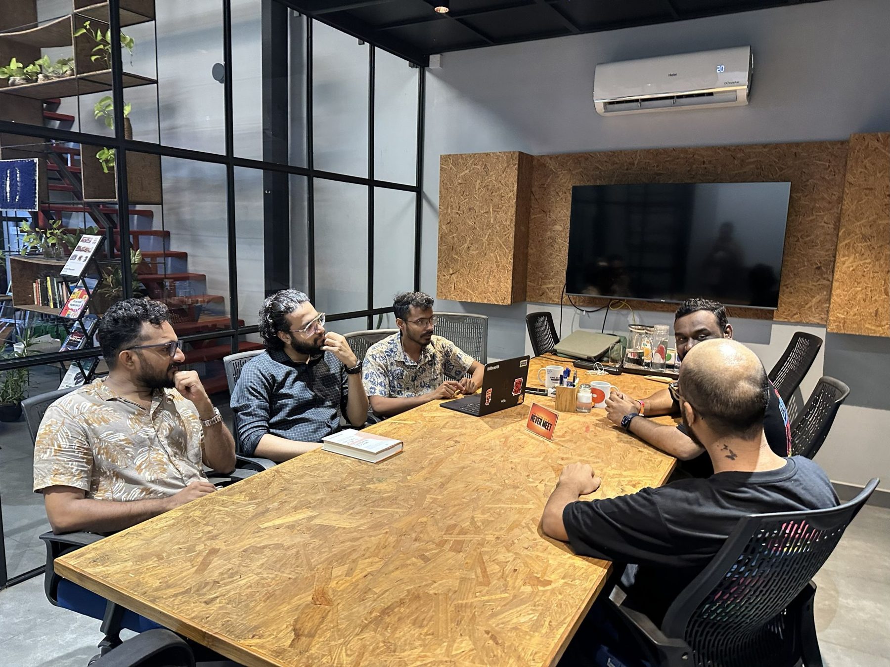 The NPoC and TinkerHub teams around a table at TinkerSpace, Kochi